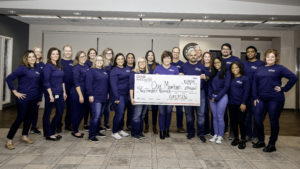 Our staff posing with a check made out to "Our Members for $200,000