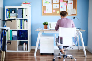 Man at a stylish desk working on a laptop paying bills