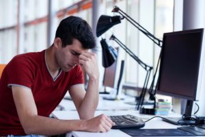 frustrated man sitting at a computer